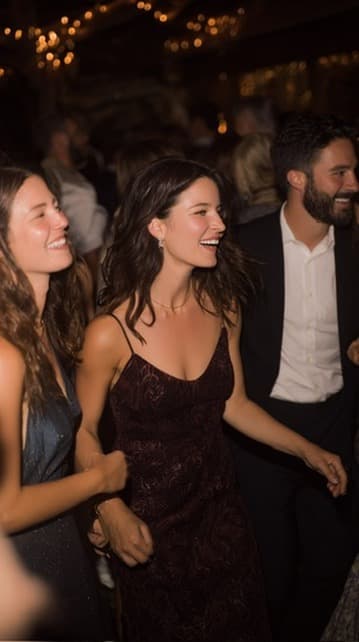 Friends laughing on a dance floor under fairy lights